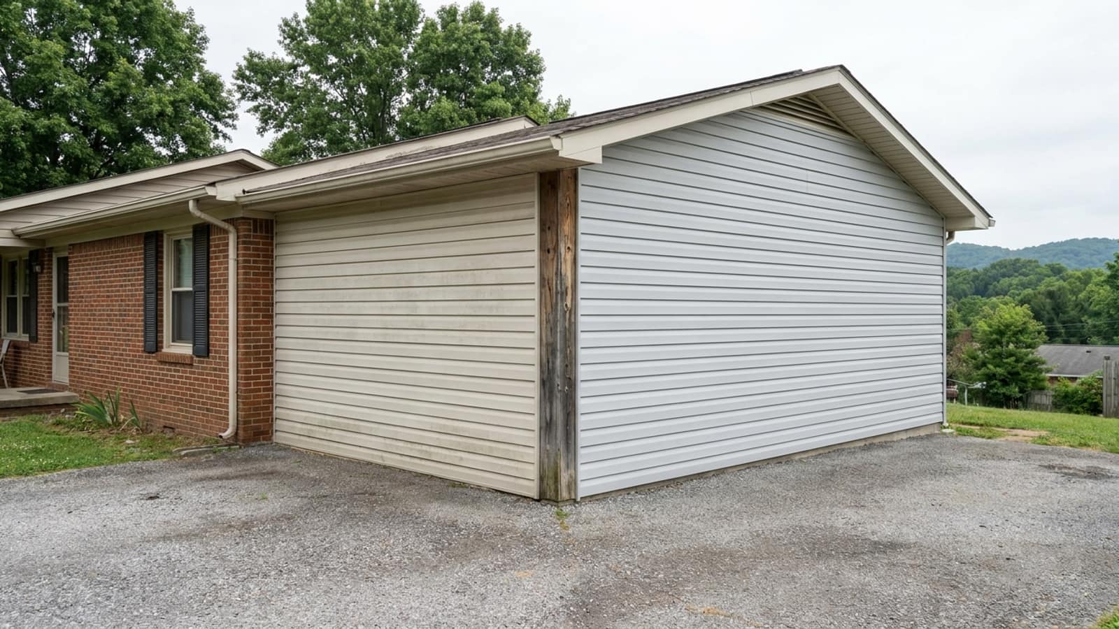 Exterior corner of a suburban home where one faded chalky siding wall meets a clean newer siding wall at the corner post